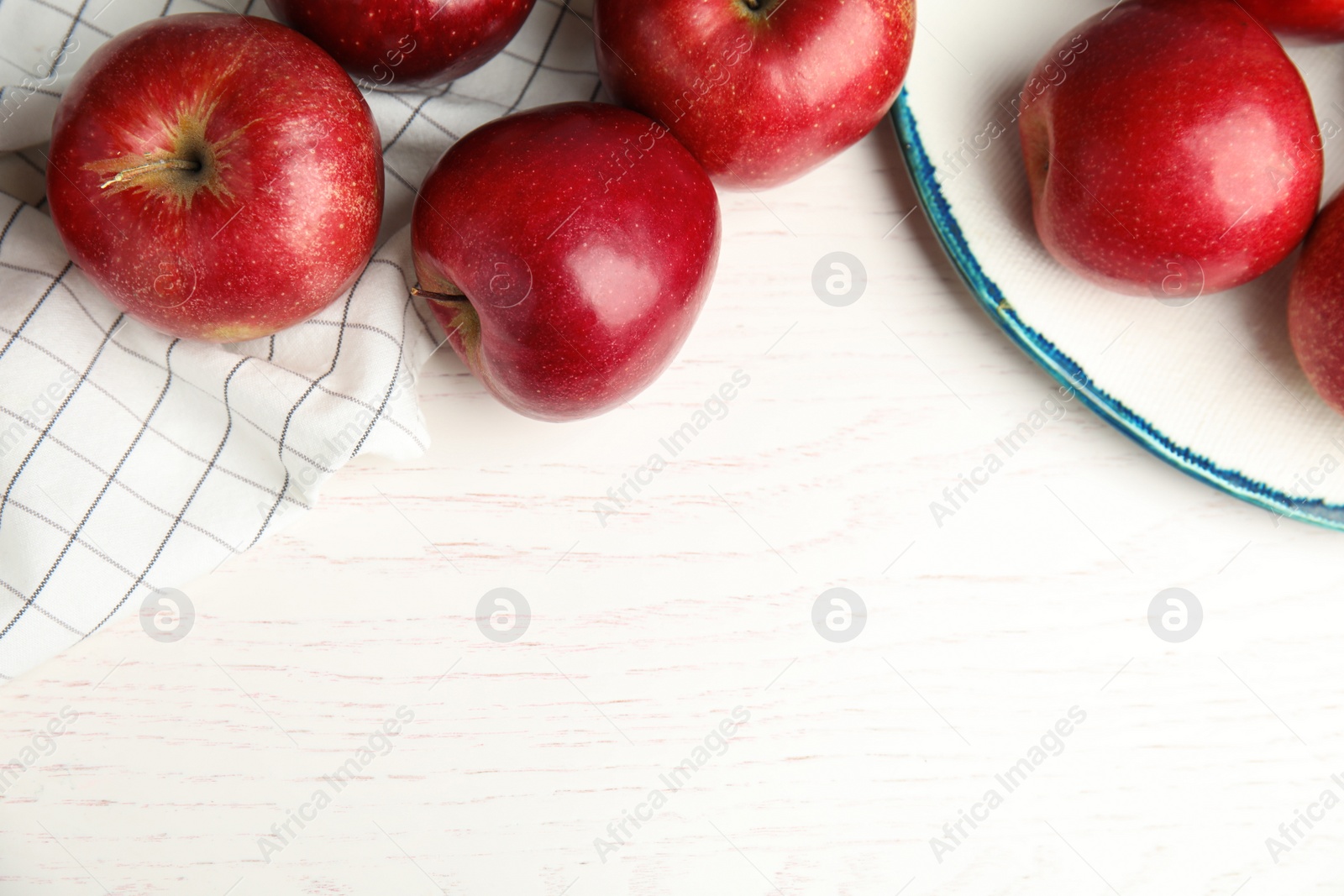 Photo of Ripe juicy red apples on white wooden background, flat lay. Space for text