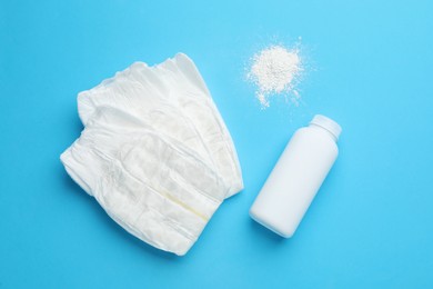 Photo of Dusting powder and diapers on light blue background, flat lay. Baby care products