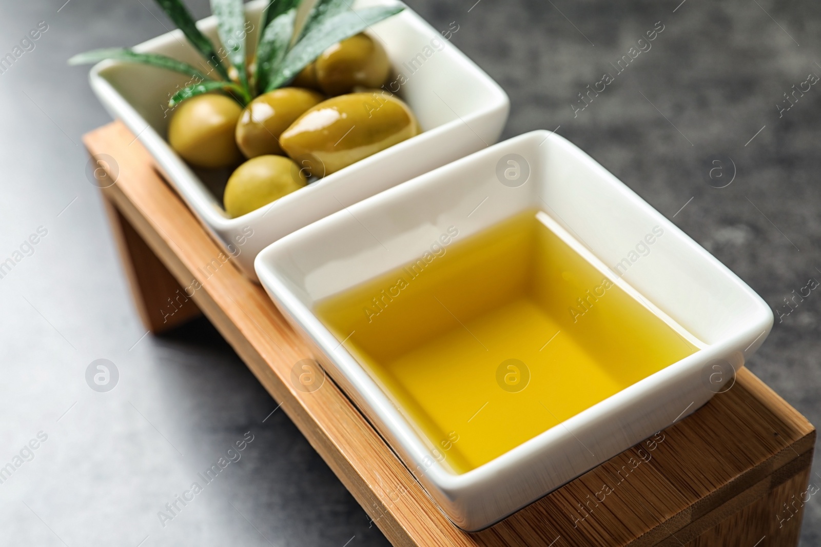 Photo of Dishes with oil and olives on table, closeup