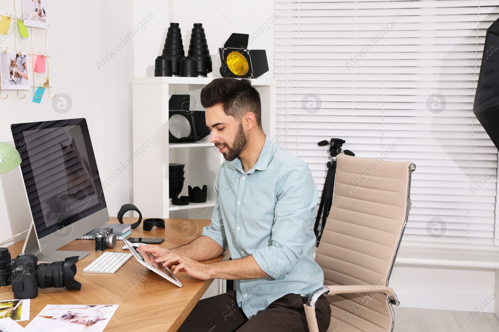 Photo of Professional photographer working at table in office