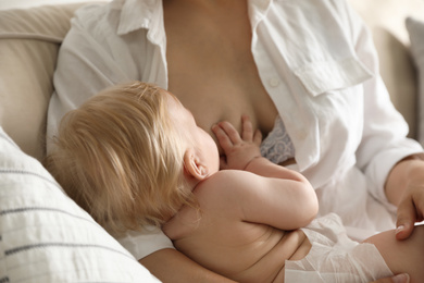 Photo of Mother breastfeeding her little baby at home. Healthy growth