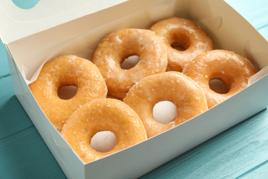 Photo of Delicious donuts on light blue table, closeup