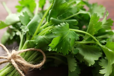 Photo of Bunch of fresh coriander on table, closeup