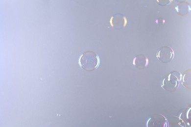 Photo of Beautiful transparent soap bubbles on gray background