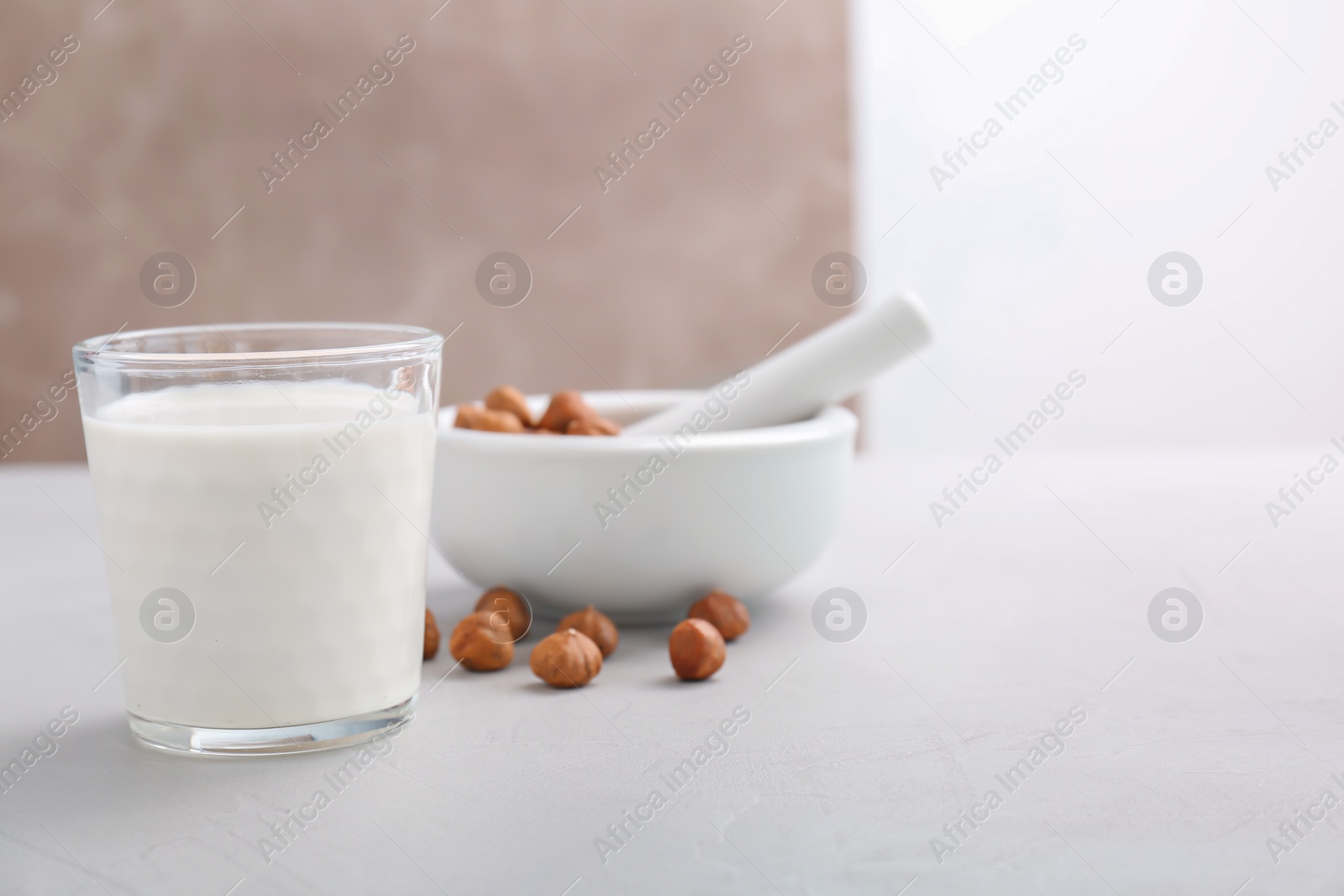 Photo of Glass with hazelnut milk on table