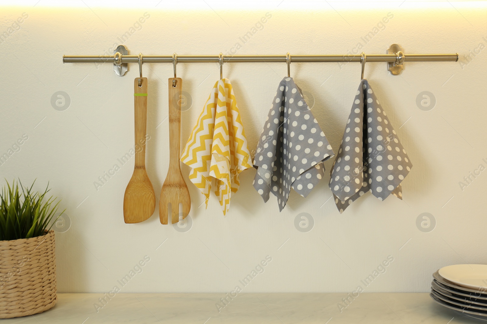 Photo of Different kitchen towels hanging on hook rack indoors