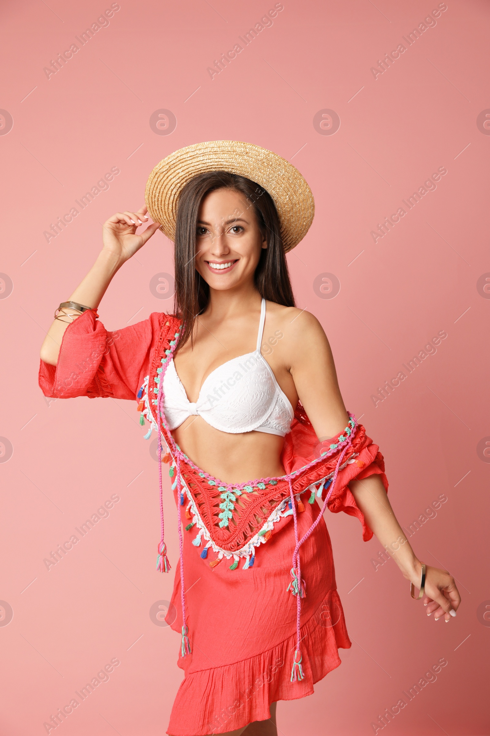 Photo of Pretty sexy woman with slim body in stylish  white bikini on coral background