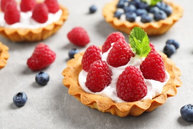 Photo of Delicious sweet pastry with berries on grey table, closeup