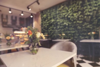 Stylish cafe interior with furniture, blurred view