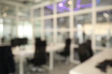 Photo of Blurred view of cozy workspaces with tables and chairs in office