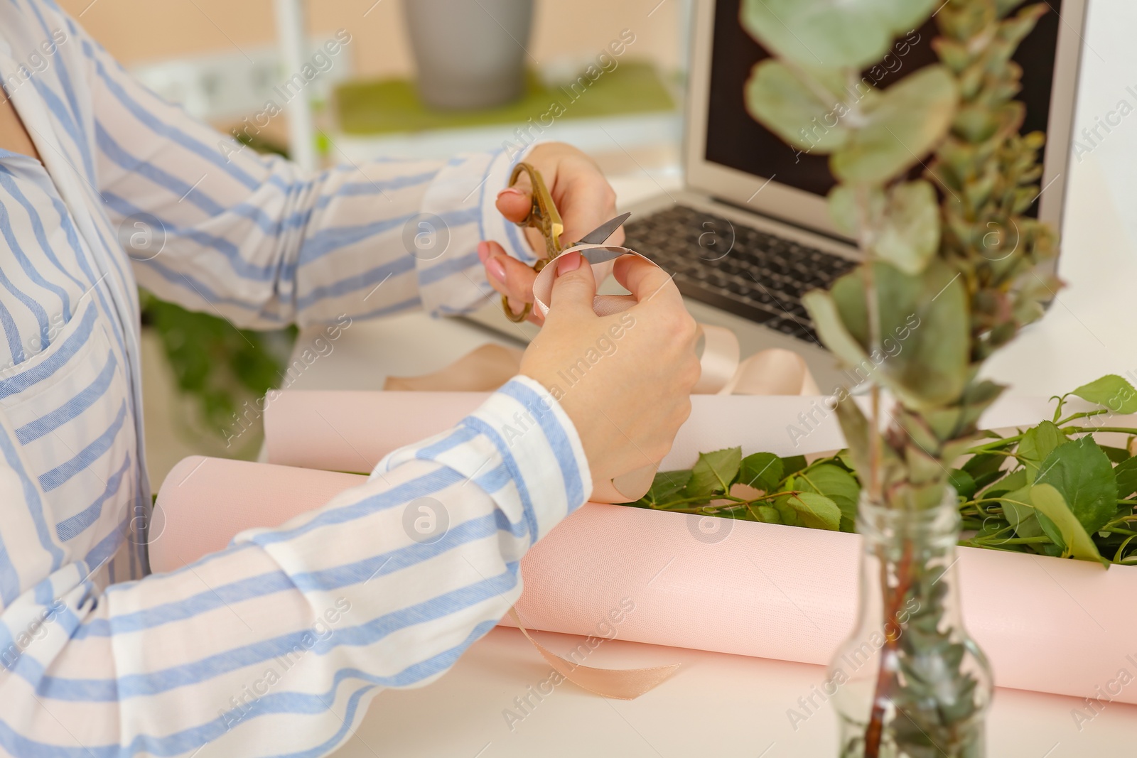 Photo of Woman making bouquet following online florist course at home, closeup. Time for hobby