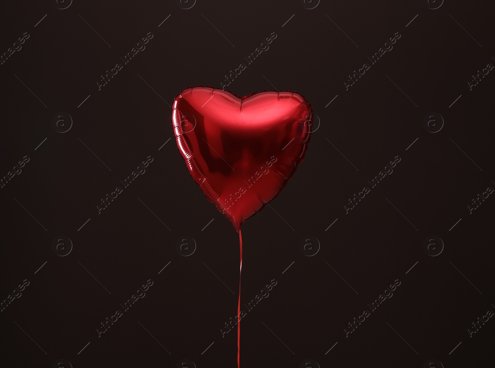 Photo of Festive heart shaped balloon on dark background