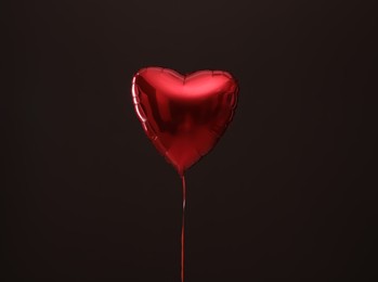 Photo of Festive heart shaped balloon on dark background