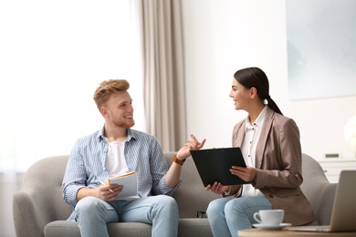 Female insurance agent consulting young man in office