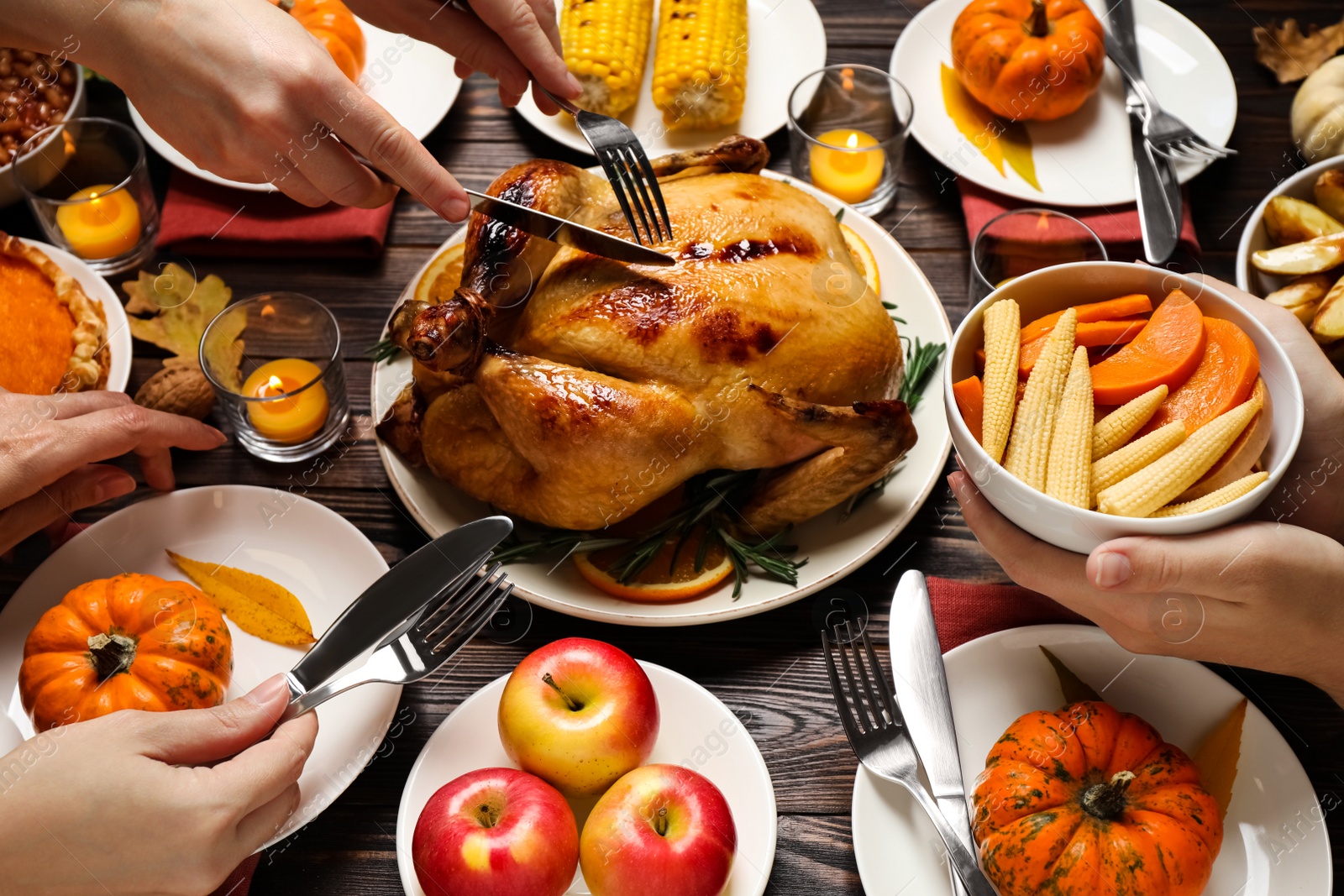 Photo of People eating traditional cooked turkey at wooden table, closeup. Thanksgiving day celebration