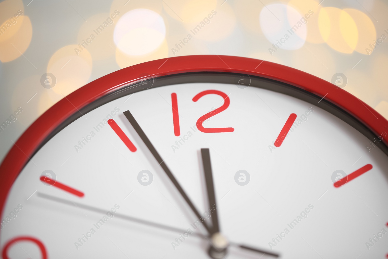 Photo of Clock showing five minutes until midnight on blurred background, closeup. New Year countdown