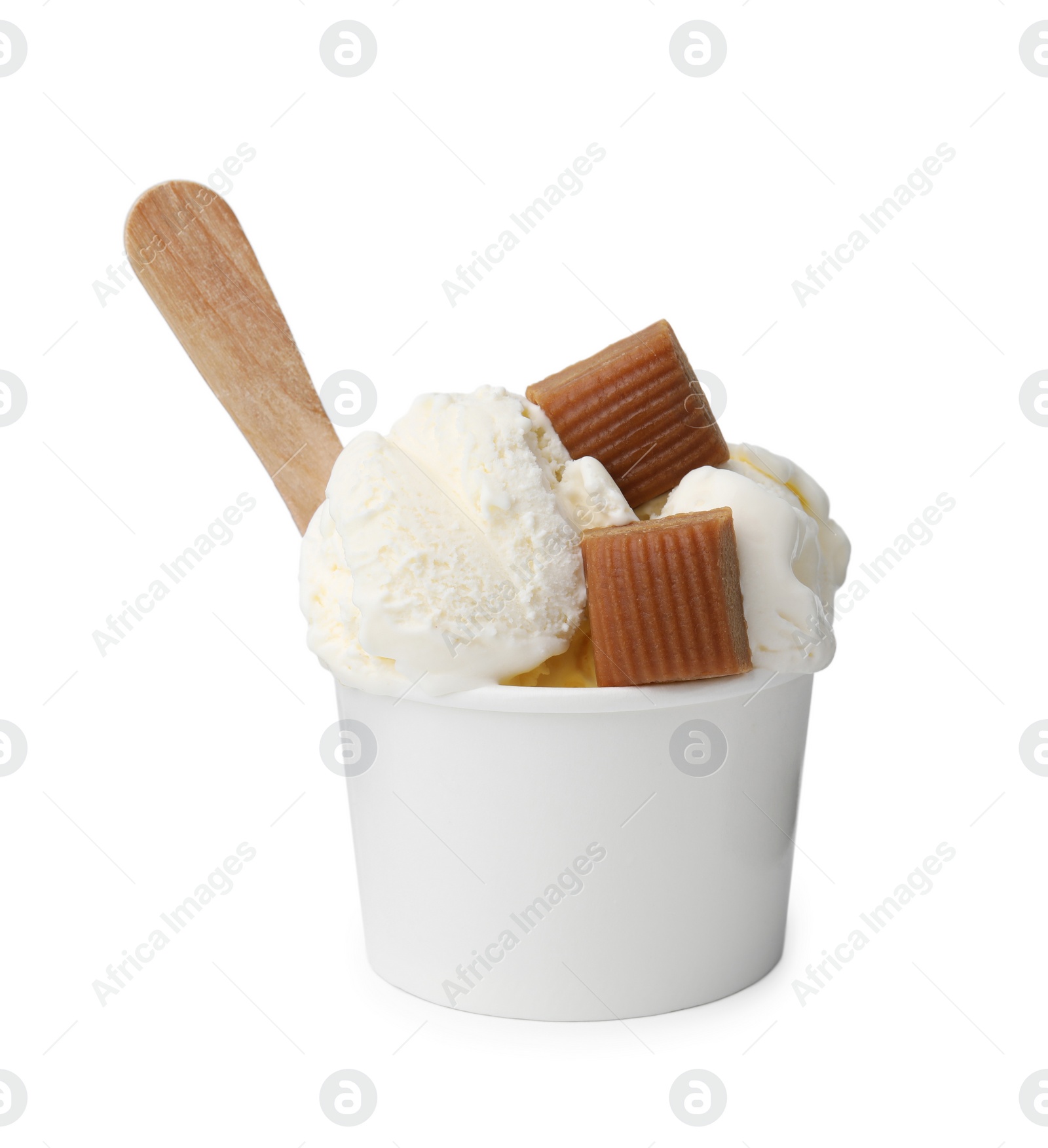 Photo of Scoops of delicious ice cream with caramel candies in paper cup isolated on white
