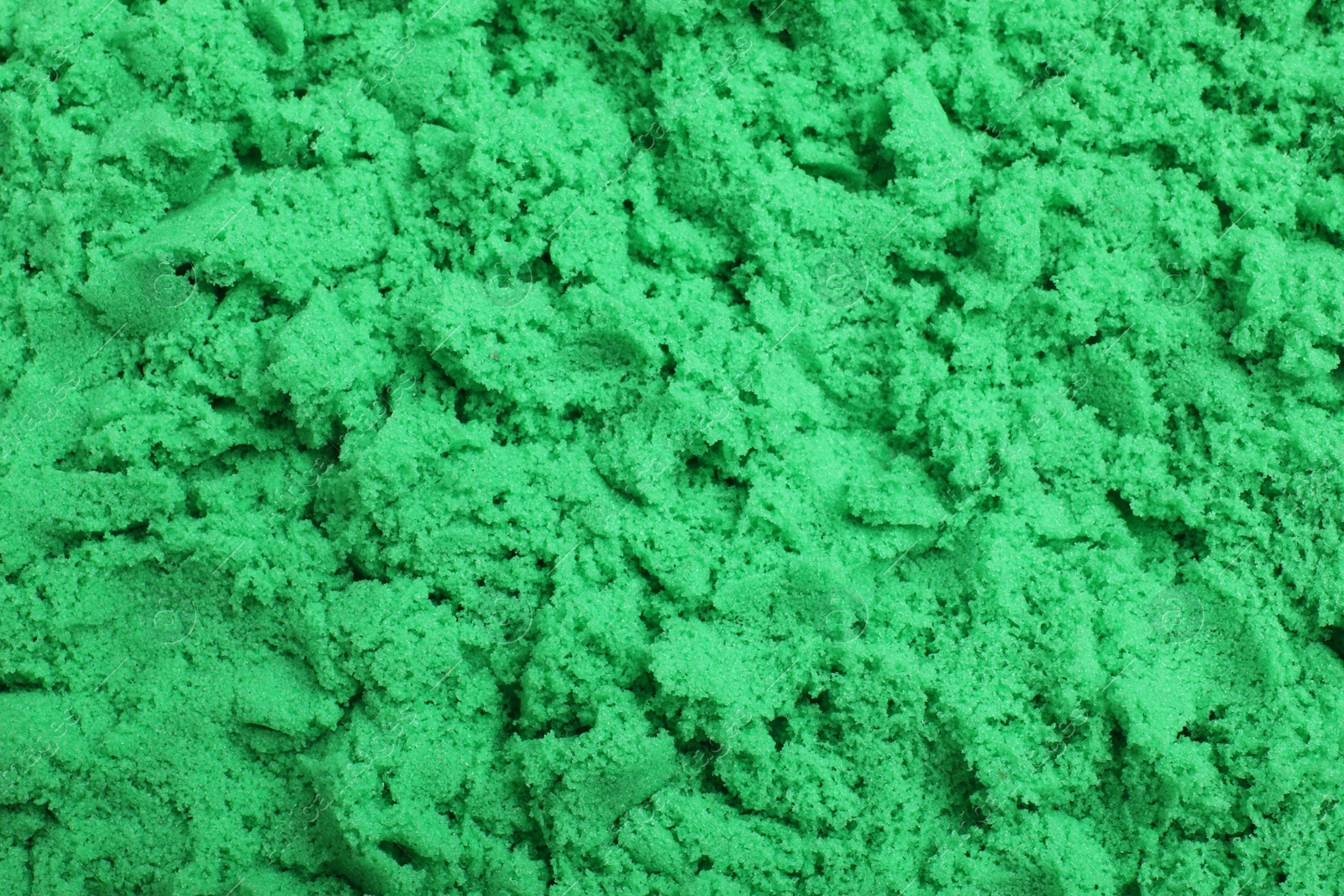 Photo of Green kinetic sand as background, closeup view