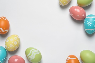 Colorful painted Easter eggs on white background, top view