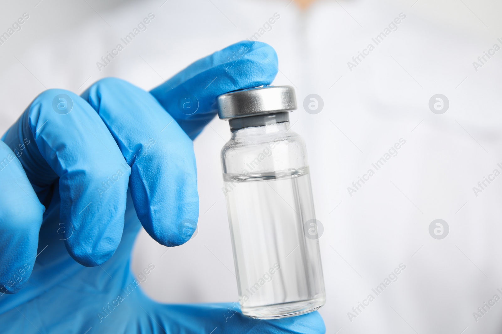 Photo of Doctor holding vial with medication, closeup. Vaccination and immunization