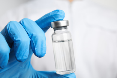 Doctor holding vial with medication, closeup. Vaccination and immunization