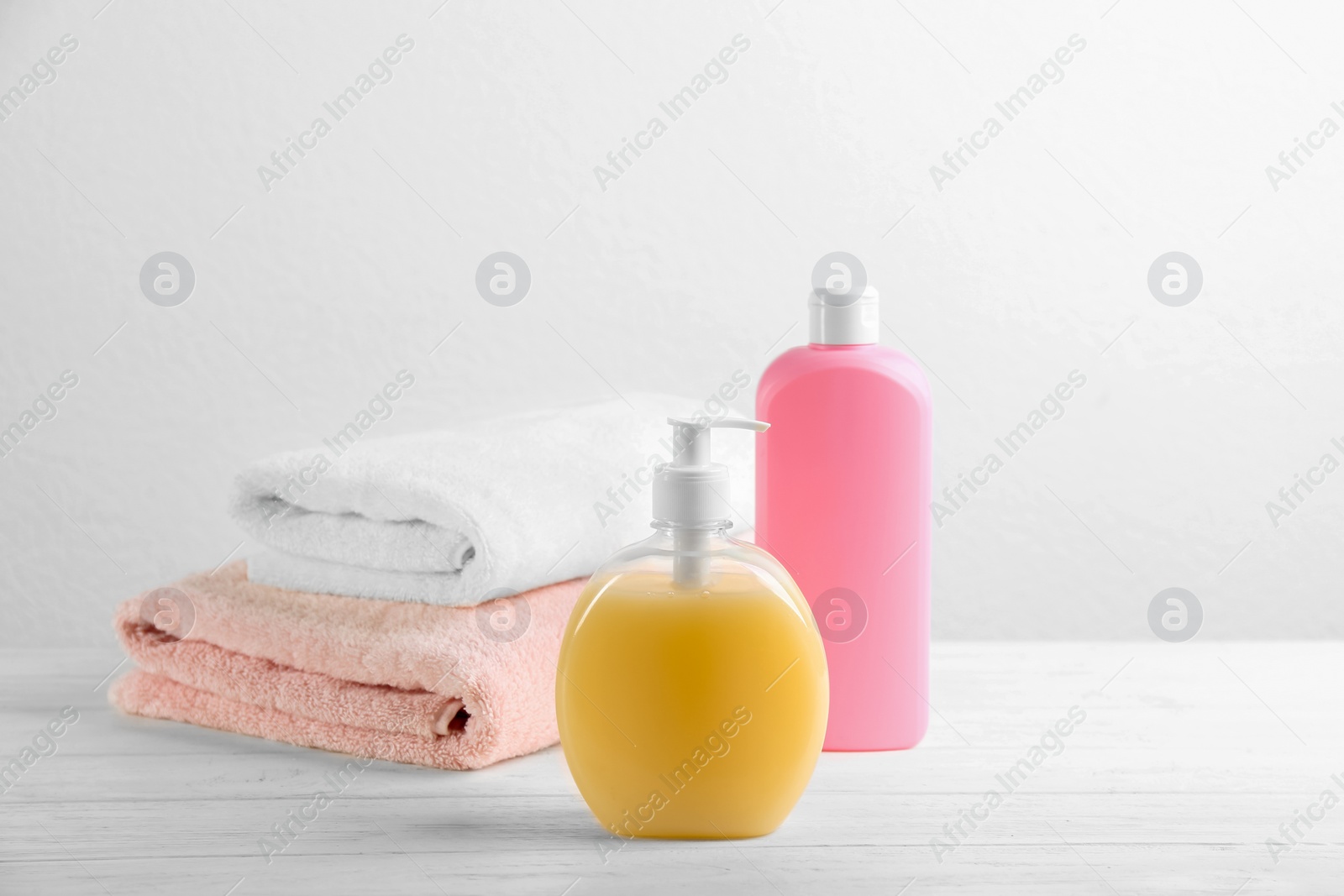 Photo of Fresh towels and toiletries on white wooden table