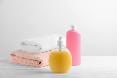 Photo of Fresh towels and toiletries on white wooden table