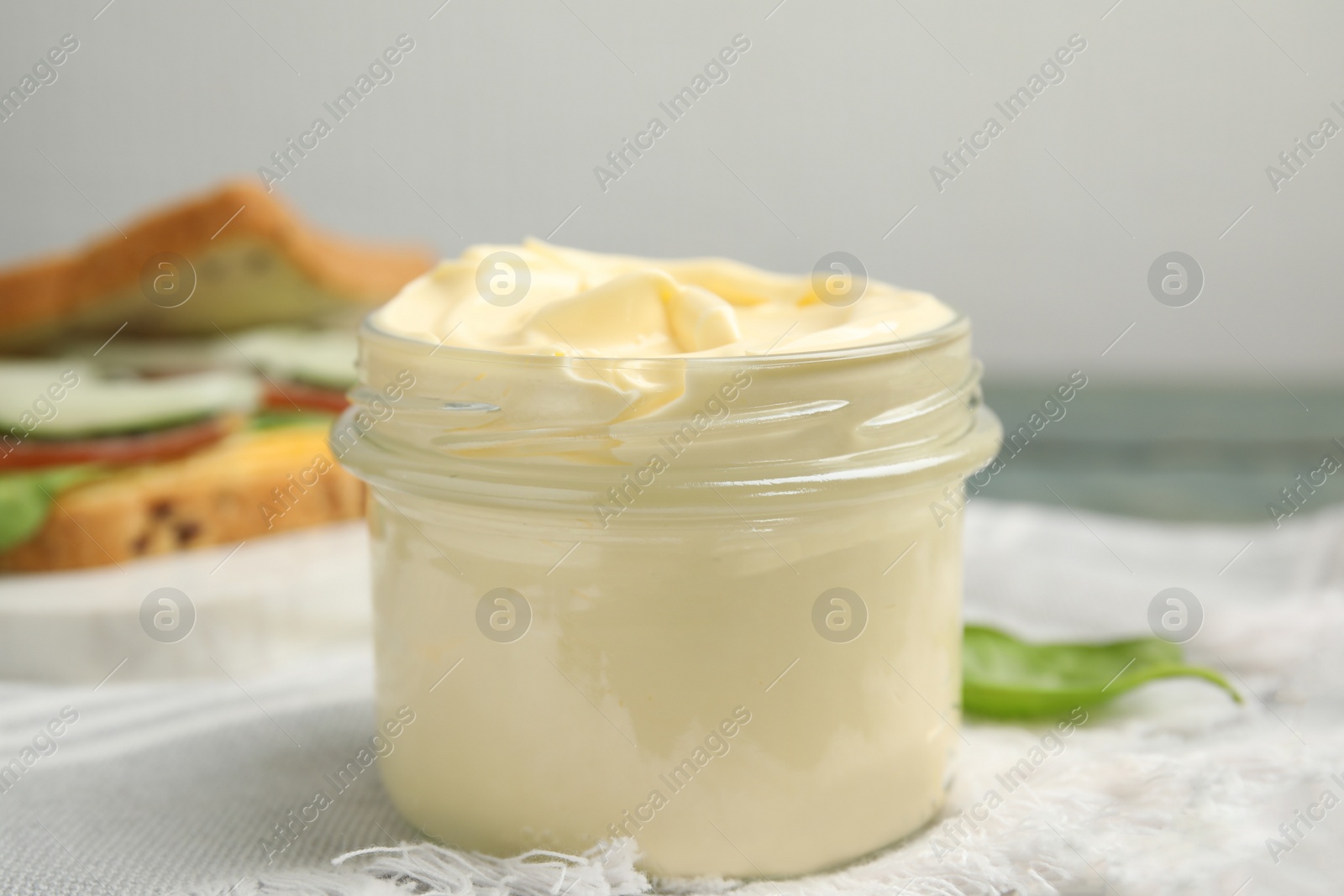 Photo of Jar of delicious mayonnaise on table, closeup