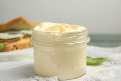 Jar of delicious mayonnaise on table, closeup