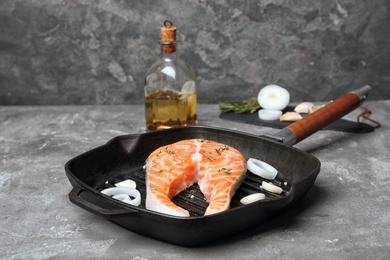 Photo of Frying pan with fresh raw salmon steak on table