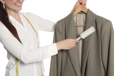 Woman using adhesive lint roller on white background, closeup. Dry-cleaning service