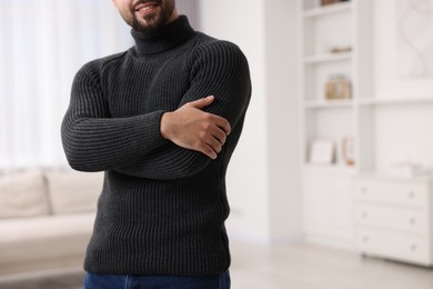 Man in stylish sweater at home, closeup. Space for text