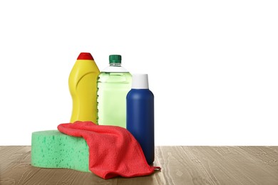 Photo of Bottles, cloth and car wash sponge on wooden table against white background