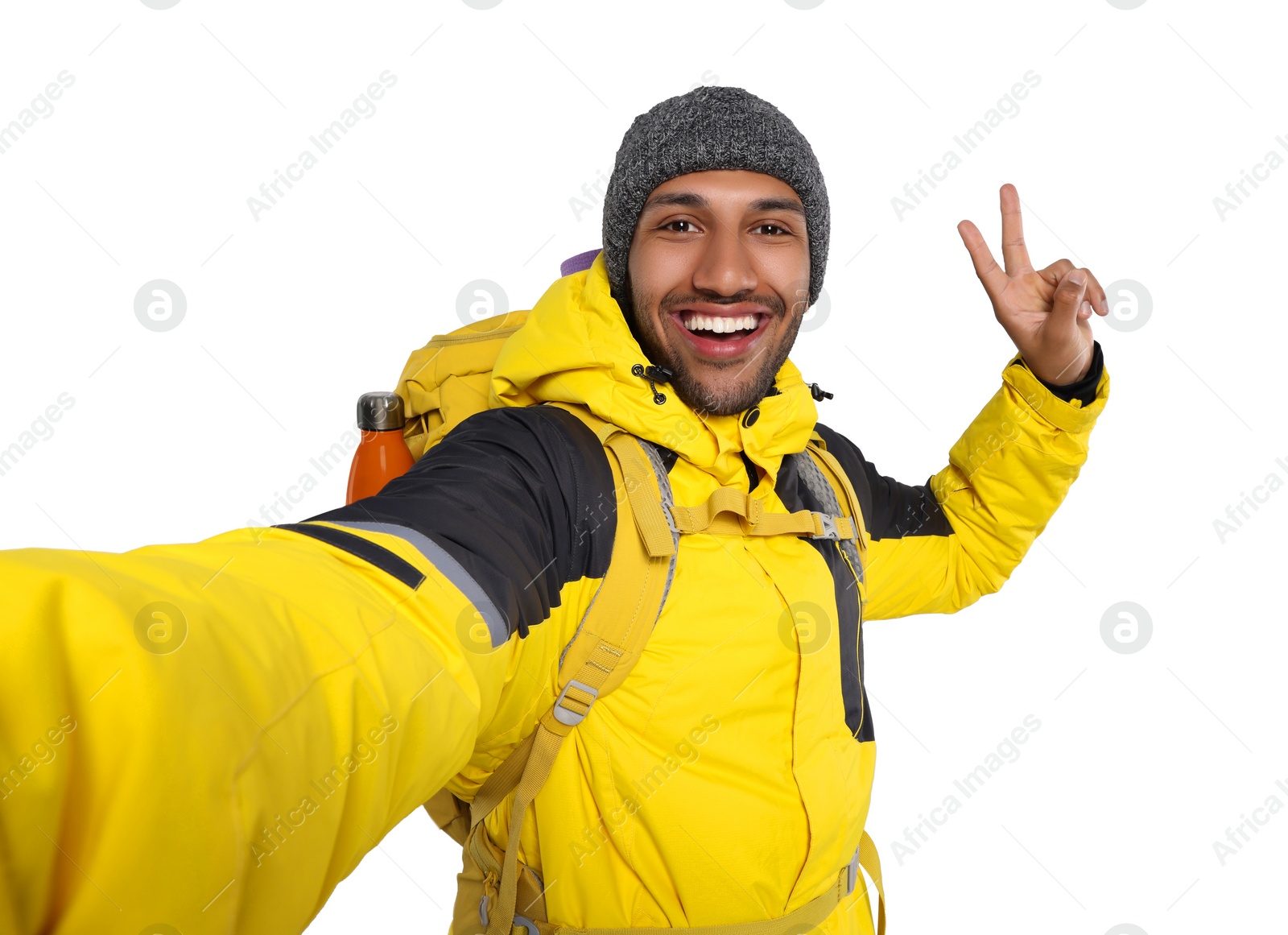 Photo of Happy tourist with backpack taking selfie on white background