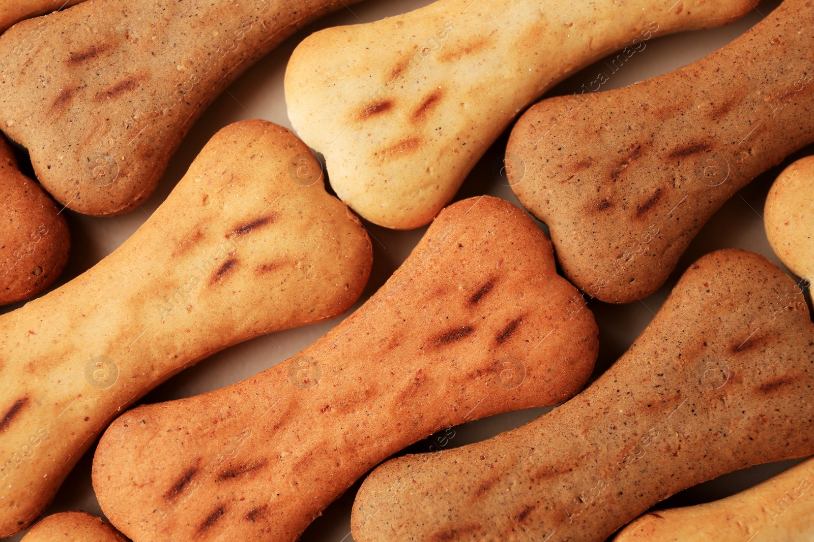 Photo of Bone shaped dog cookies as background, top view