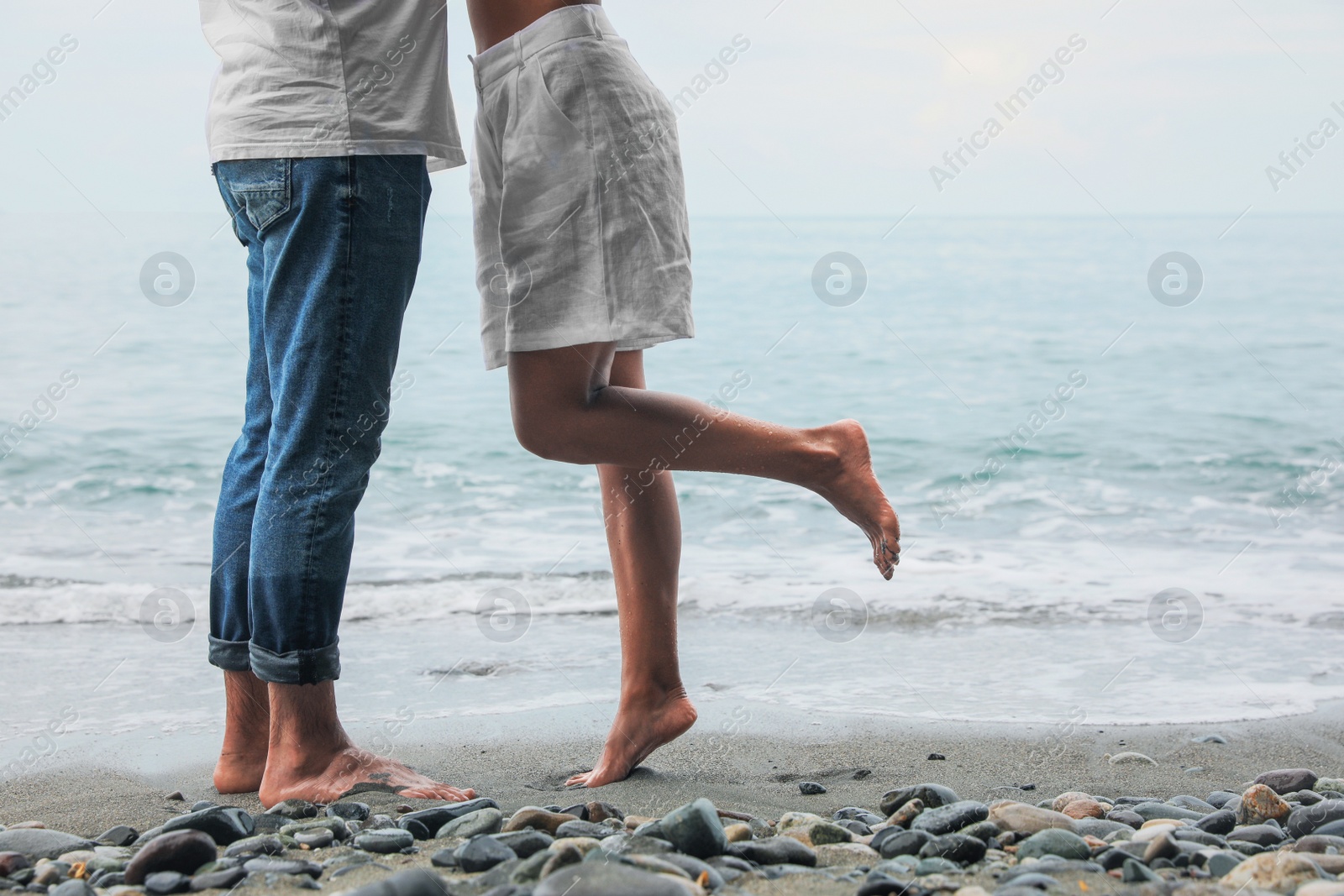 Photo of Young couple on beach near sea, closeup. Space for text