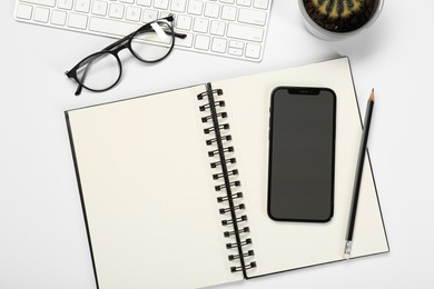 Photo of Flat lay composition with open notebook and smartphone on white table