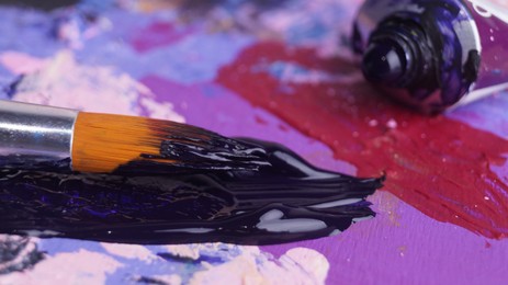 Photo of Artist's palette with mixed paints, tube and brush, closeup