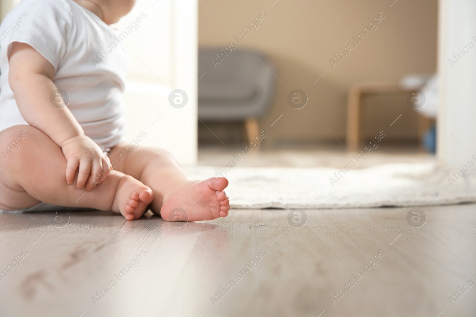 Photo of Cute little baby on floor indoors, closeup with space for text. Crawling time