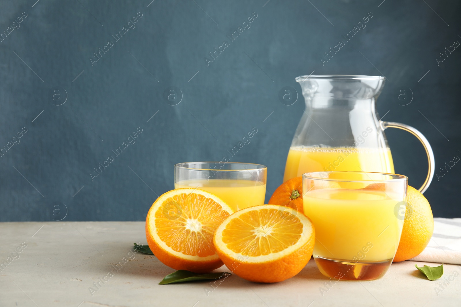 Photo of Composition with orange juice and fresh fruit on table, space for text