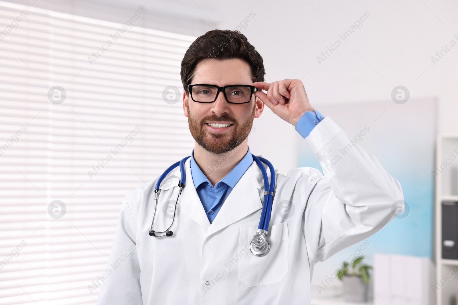 Photo of Medical consultant with glasses and stethoscope in clinic