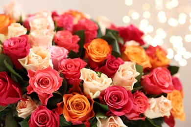 Photo of Beautiful bouquet of colorful roses on beige background, closeup