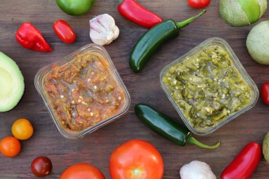 Tasty salsa sauces and ingredients on wooden table, flat lay