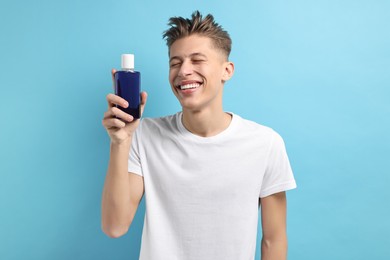Photo of Young man with mouthwash on light blue background