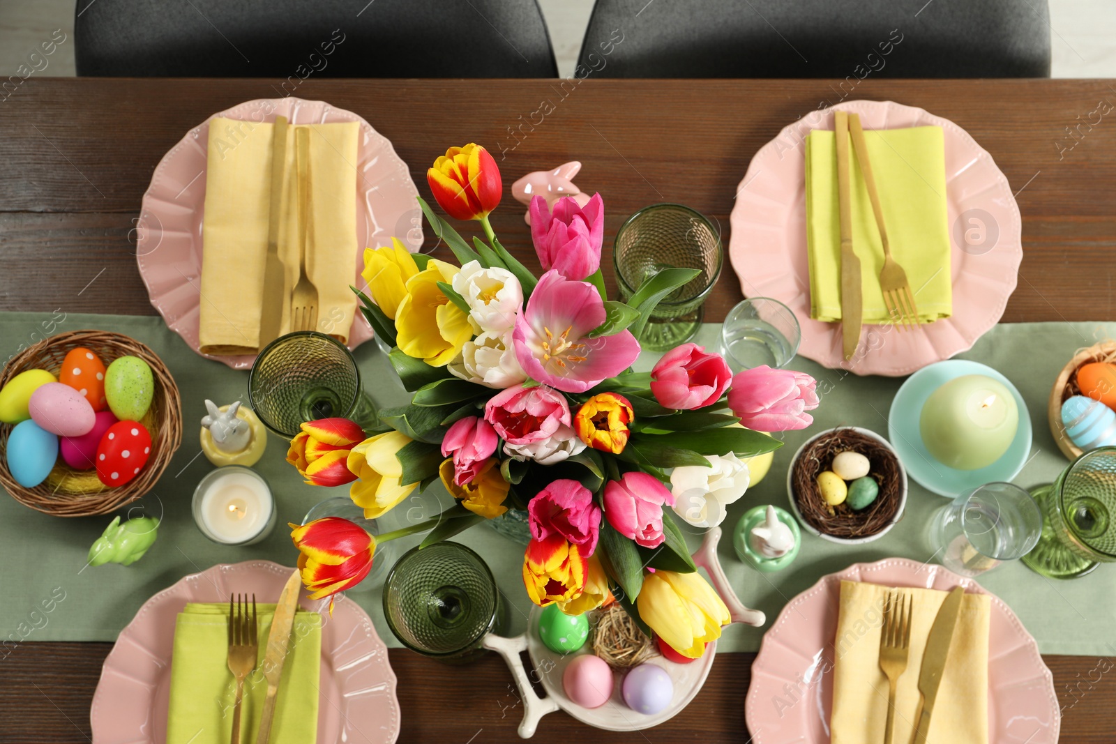 Photo of Festive Easter table setting with beautiful flowers and painted eggs, top view