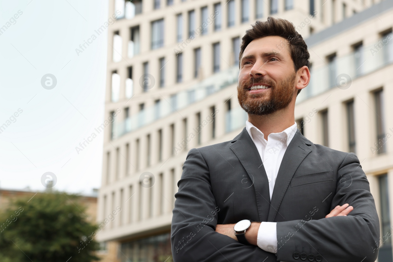 Photo of Handsome bearded businessman on city street, space for text