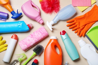 Flat lay composition with cleaning supplies on wooden background