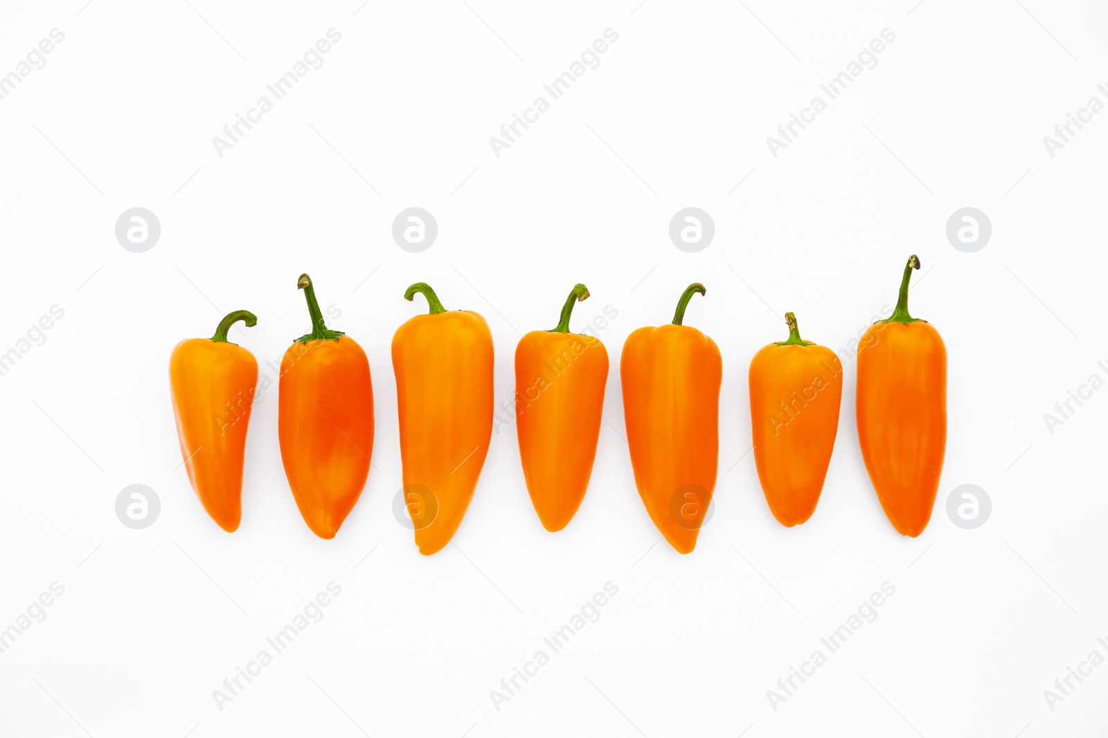 Photo of Fresh raw orange hot chili peppers on white background, top view