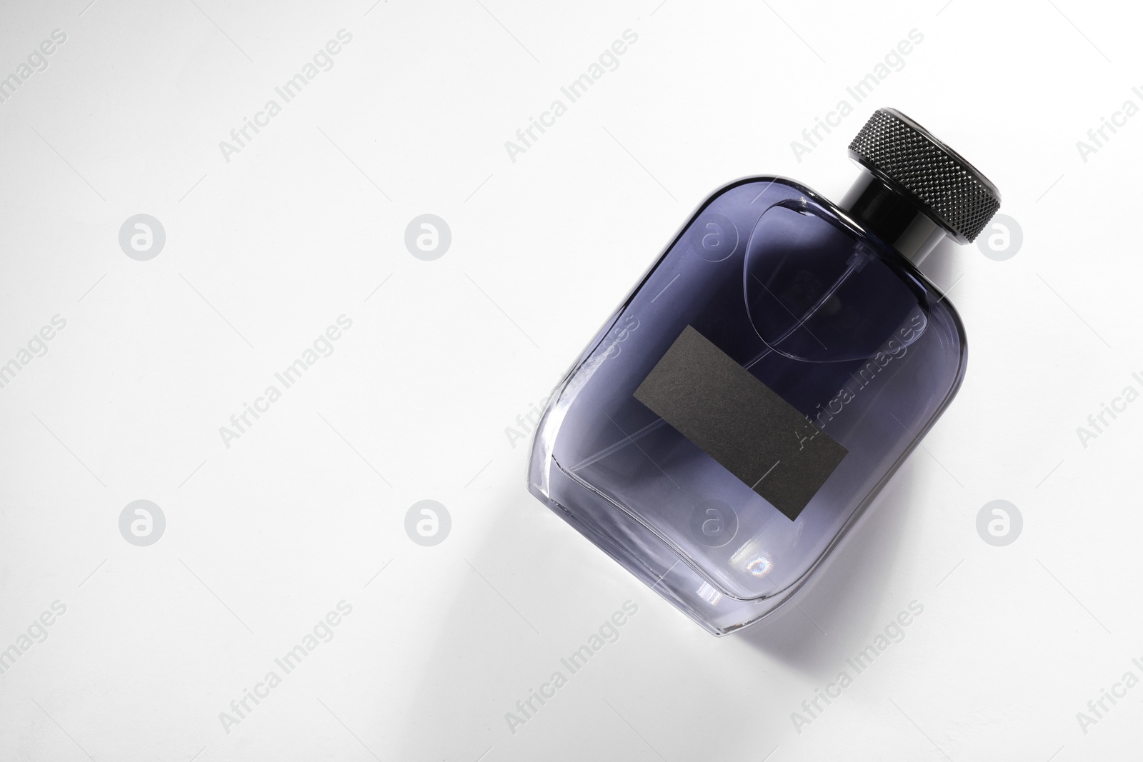 Photo of Luxury men`s perfume in bottle on white background, top view. Space for text