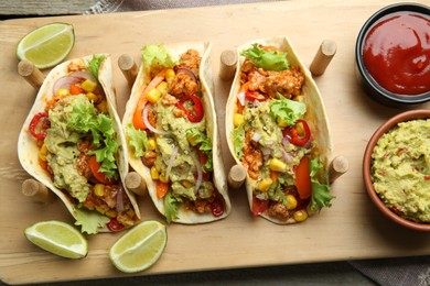 Photo of Delicious tacos with guacamole, meat and vegetables served on table, top view